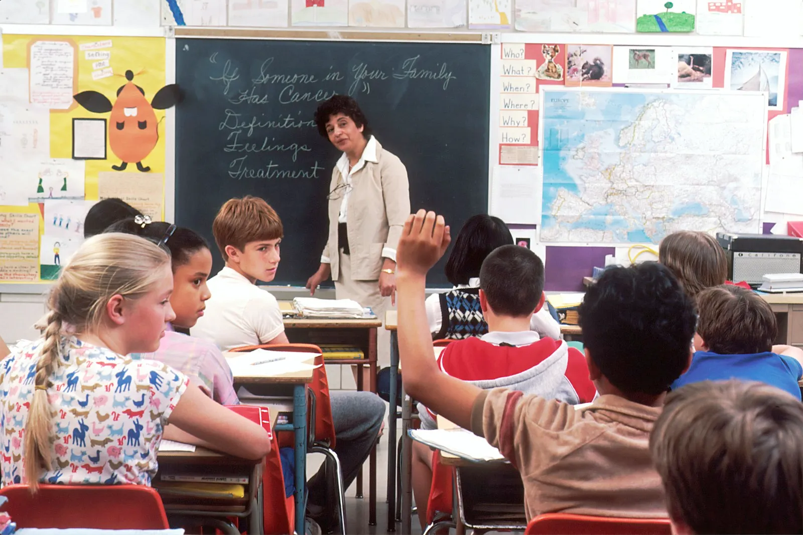 Tutor guiding elementary students in class