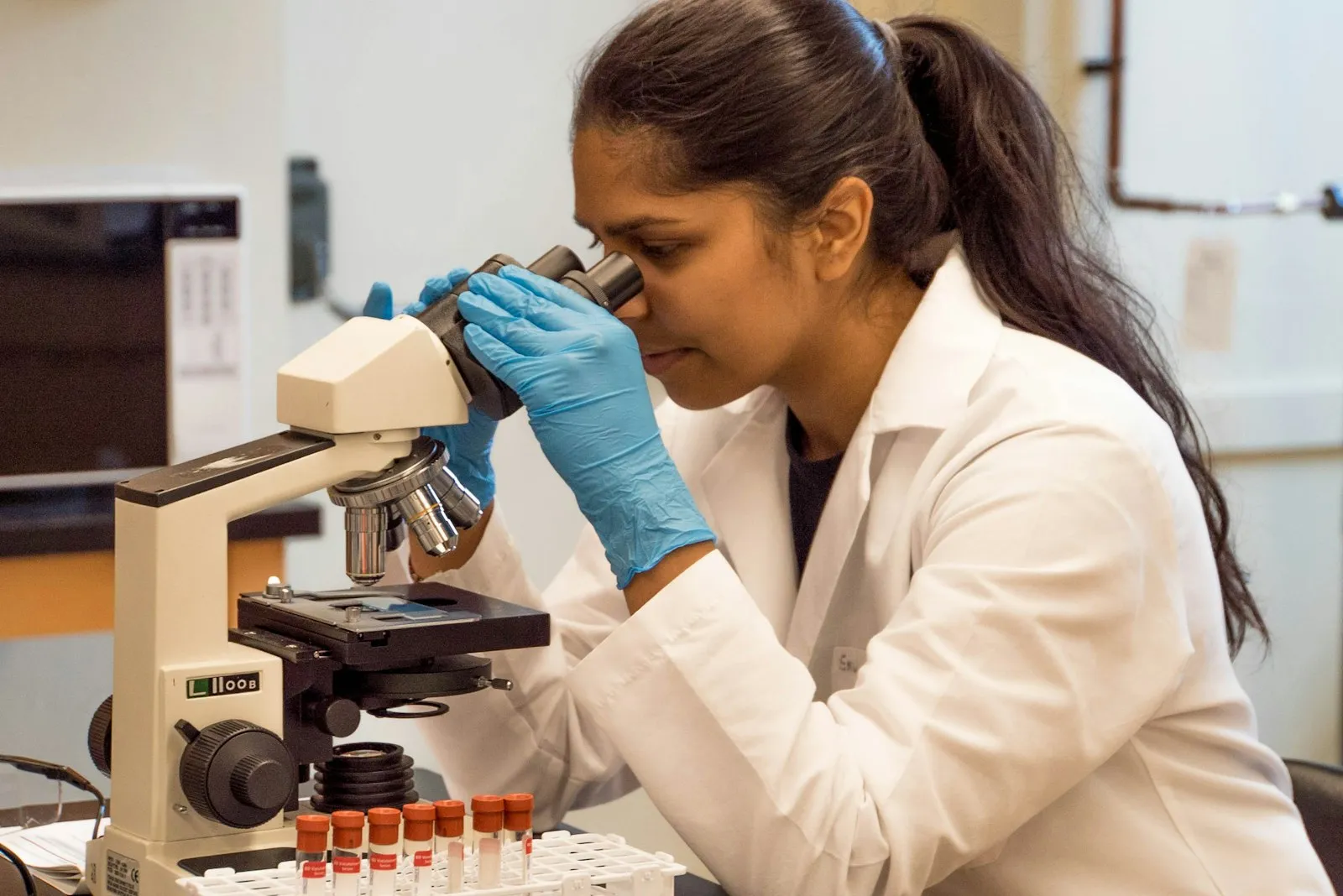 Olympiad student examining a sample through a microscope